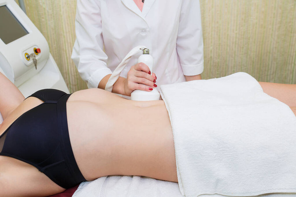 Anti-cellulite massage on the abdomen in the beauty salon. - Foto, imagen