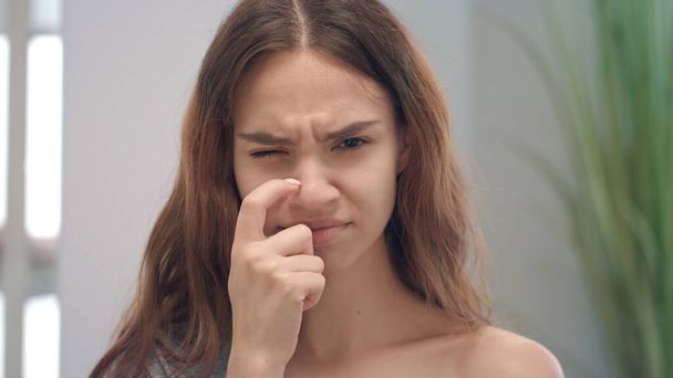 Jeune femme allergique grattant nez caméra avant. Symptômes de grippe chez la femme - Photo, image