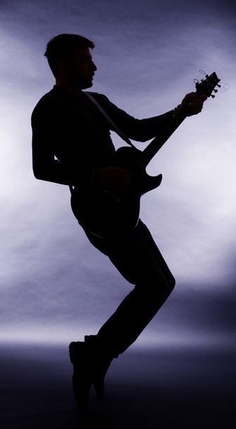 Guitarist silhouette on dark gray background - Fotografie, Obrázek