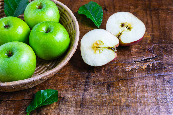 Πράσινο μήλο σε καλάθι σε ξύλινο τραπέζι - Φωτογραφία, εικόνα