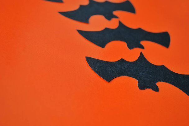 Czarne papierowe nietoperze leżą na pomarańczowym tle - Zdjęcie, obraz