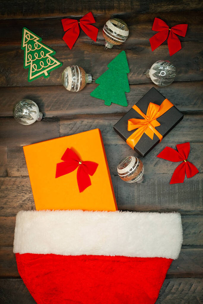 Gros plan sur les décorations de Noël et les cadeaux du Nouvel An pour Noël ou le Nouvel An, couché sur un fond en bois. Cadeaux du chapeau du Père Noël. Concept festif - Photo, image