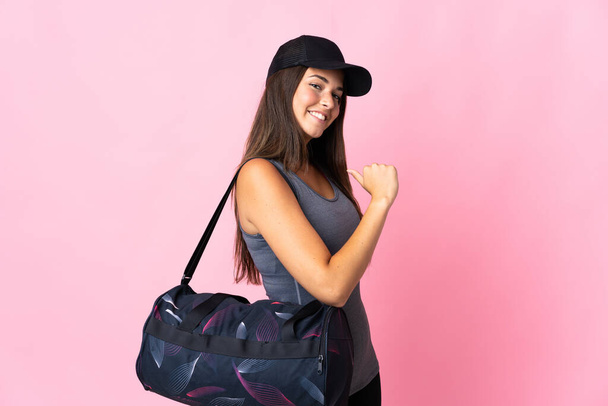 Young sport brazilian girl with sport bag isolated on pink background proud and self-satisfied - Foto, Imagem