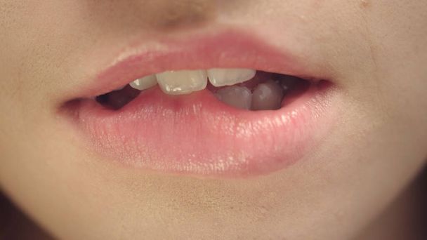 Женское лицо чувственной женщины кусающей и облизывающей пухлые губы. Сексуальные губы и рот - Фото, изображение