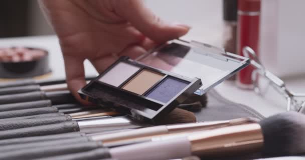 Close up tiro de maquilhagem artista tomando sombras em escova especial - Filmagem, Vídeo