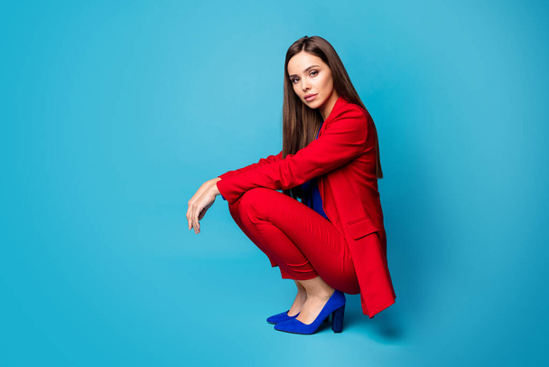 Full body profile photo of cool business lady successful worker sitting self-confident person wear trend red suit blouse shirt blazer pants high-heels isolated blue color background - Valokuva, kuva