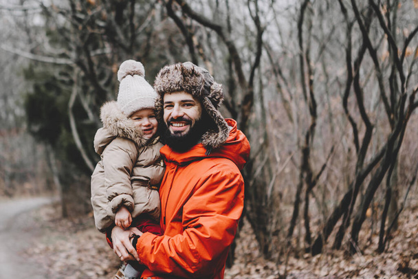 Handsome young dad and his little sweet daughter have fun outdoors in winter. Happy family spending time together. Family concept. - Photo, image