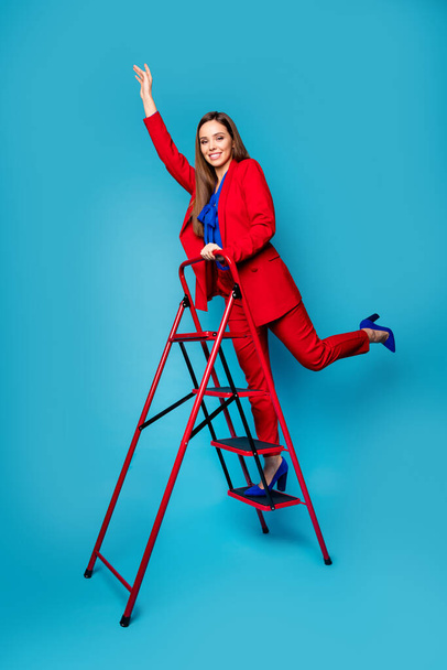 Full length vertical photo of professional fancy lady successful worker come up career ladder wear luxury red suit blouse shirt blazer pants high-heels isolated blue color background - Fotografie, Obrázek