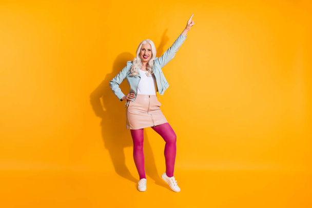 Dancing queen. Full size photo of positive cheerful old woman enjoy night club moving party raise index finger up wear good look stocking shoes isolated over shine color background - Fotó, kép
