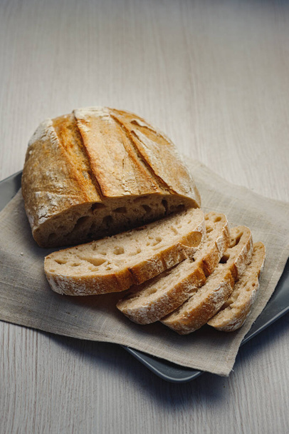 Freshly baked tartin bread cut into slices on a plate - Foto, Imagem