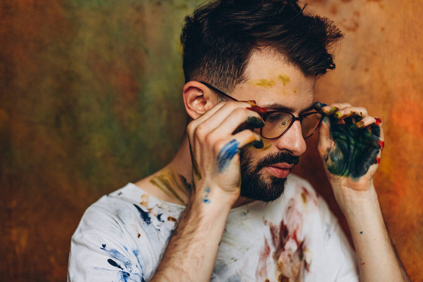 Portrait of a young creative artist, A man who enjoys drawing, his favorite hobby paint colors on a canvas - Fotoğraf, Görsel