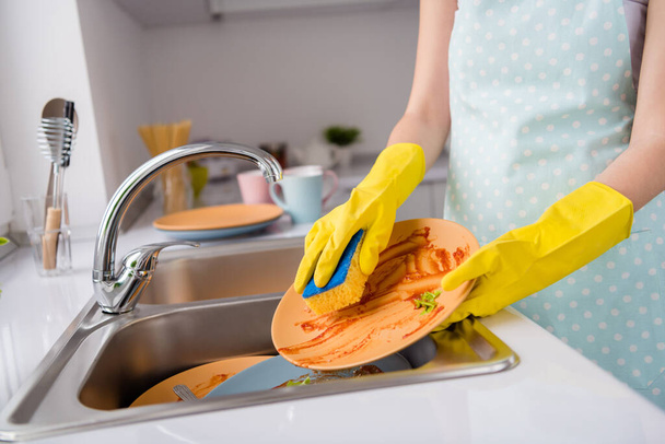 Recortado de cerca la foto de la criada ama de casa lavar los platos sucios después de sabrosa comida fresca orgánica usar esponja usar guantes de látex amarillo en la casa de la cocina en el interior - Foto, imagen