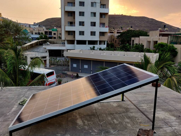 Bir yerleşim bölgesindeki bir evin çatısına yerleştirilmiş bir güneş paneli. - Fotoğraf, Görsel