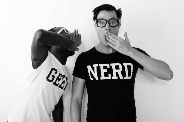 Joven hombre nerd africano con joven hombre nerd escandinavo juntos sobre fondo blanco en blanco y negro - Foto, Imagen