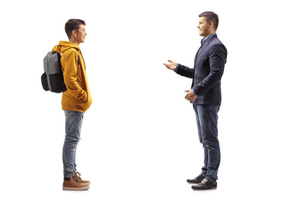 Full length profile shot of a father talking to his teenage student son isolated on white background - Φωτογραφία, εικόνα