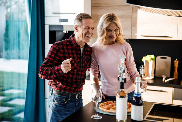 Happy adult man hugging woman on the kitchen - Photo, Image