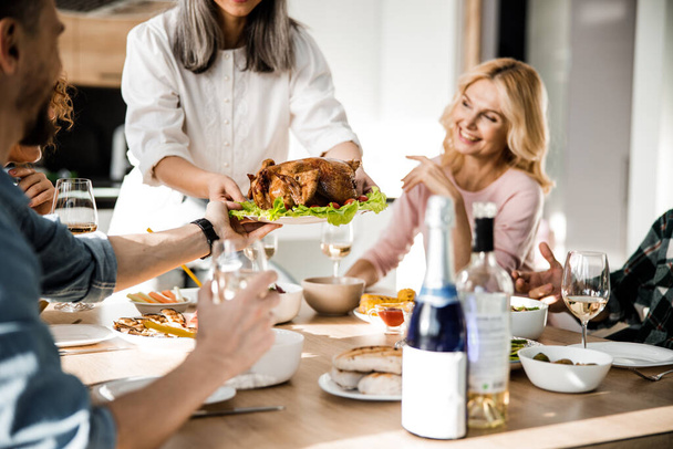 Lady mettere il cibo sul tavolo festivo per i suoi ospiti - Foto, immagini