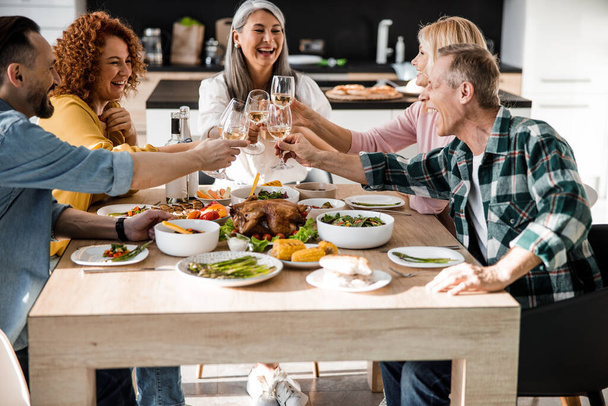 Cheerful men and women celebrating thanksgiving day together - Фото, зображення