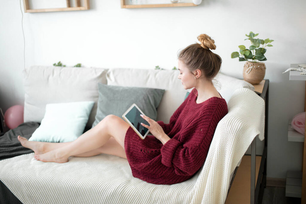 nice girl resting on the sofa and touching the scren of the tablet - Foto, immagini