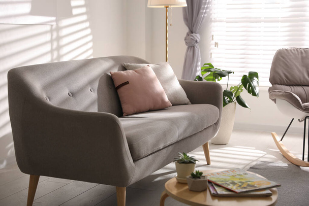 Stylish living room interior with comfortable sofa and wooden table - Φωτογραφία, εικόνα