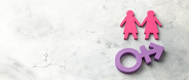 Двое лесбиянок держатся за руки на фоне трансгендерных символов - Фото, изображение