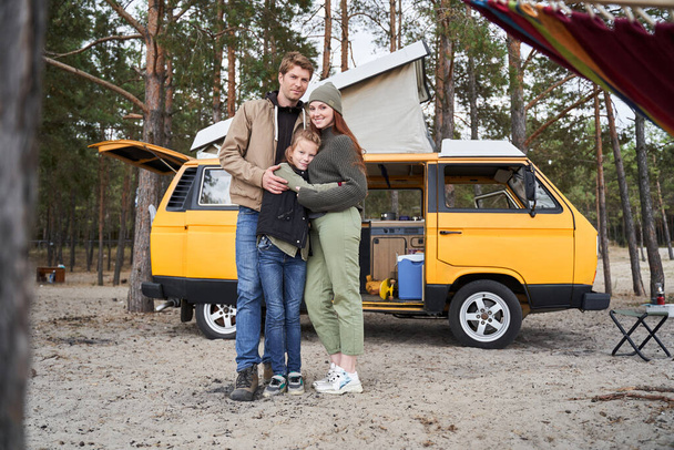 Family embracing near the car - Valokuva, kuva