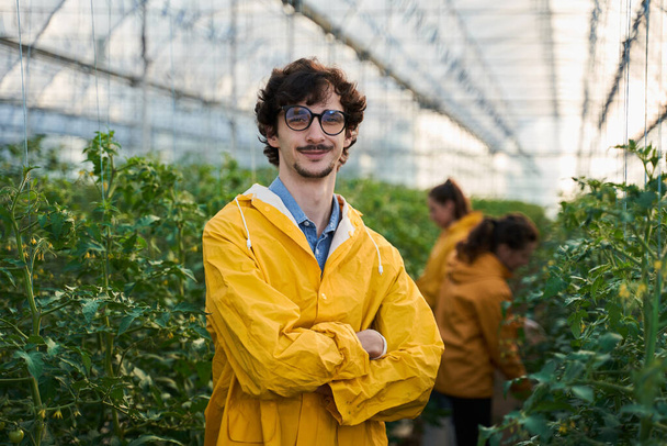 Happy young agronomist spending day in hothouse - Foto, Bild