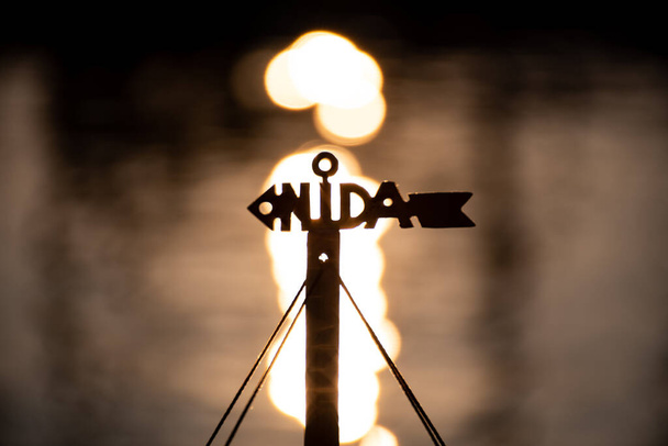 Нида, Литуания, логотип или символ с изображением солнца на фоне воды - Фото, изображение