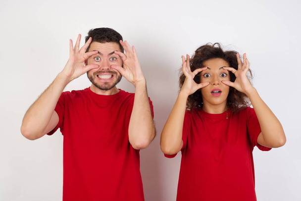 Junges Paar in roten T-Shirts posiert vor Studiohintergrund - Foto, Bild
