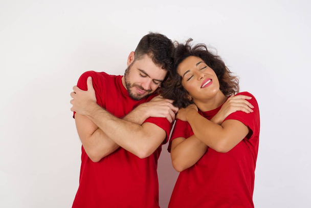 homem e mulher em estúdio, abraçando-se feliz e positivo, sorrindo confiante. Auto amor e auto cuidado - Foto, Imagem