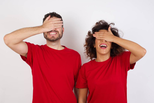 homem e mulher em estúdio, sorrindo e rindo com as mãos sobre os rostos cobrindo os olhos para surpresa. Cegos  - Foto, Imagem