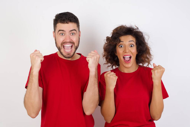 couple celebrating surprised and amazed for success with arms raised and open eyes. Winners concept. - Photo, Image