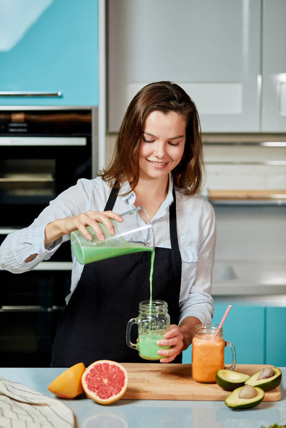positive girl preparing green cocktail for boyfriend - Фото, изображение