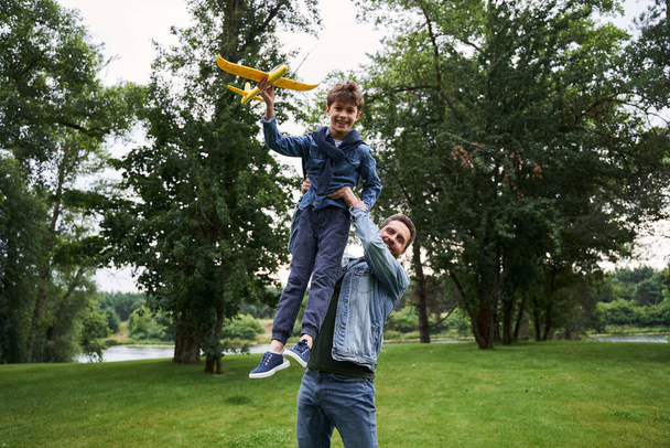 Cheerful father having fun with son outdoors - Foto, Imagen