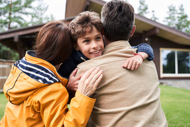 Loving parents hugging their adorable son outdoors - Foto, imagen