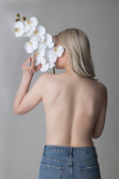 Shirtless young woman holding beautiful white flower - Fotografie, Obrázek