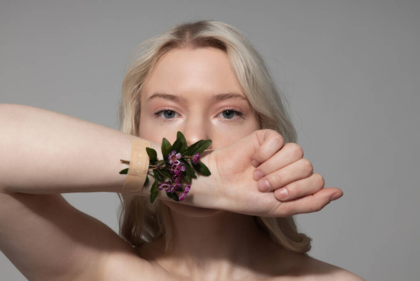 Charming young woman showing her hand with flowers - Fotoğraf, Görsel