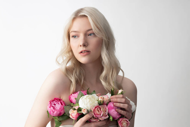 Charming young woman holding peonies and roses - Foto, Imagen