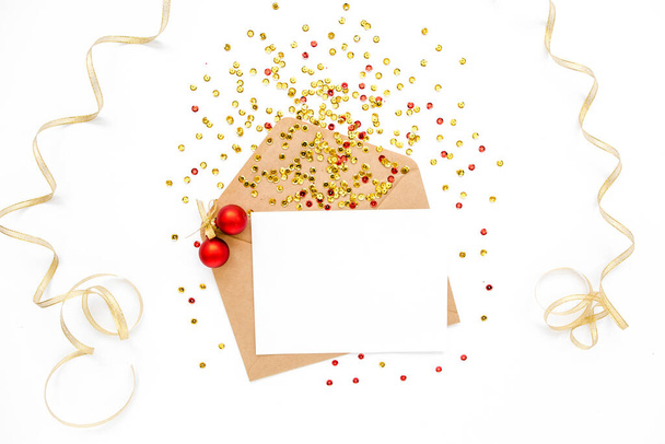 Scrivania in stile con busta, cartoncino bianco e confetti dorati isolati su fondo bianco. Piatto. Modello di burattino. Vista dall'alto - Foto, immagini