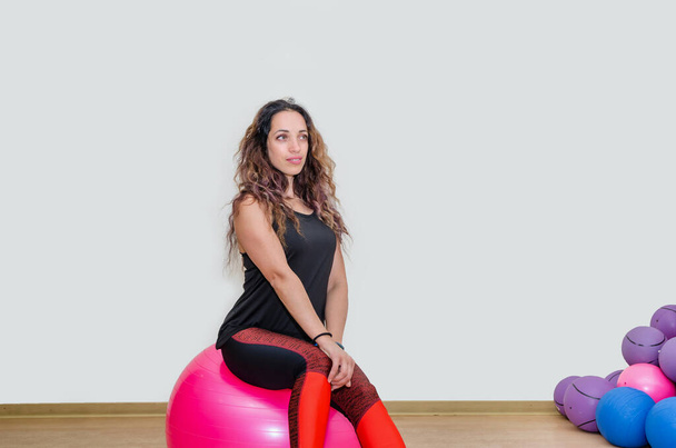 sporty girl sitting on a fitness ball or posing during training. - Photo, image