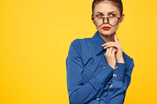 Nainen sinisessä paidassa ja lasit kirkas meikki kasvoillaan elehtii käsillään Kopioi tilaa - Valokuva, kuva