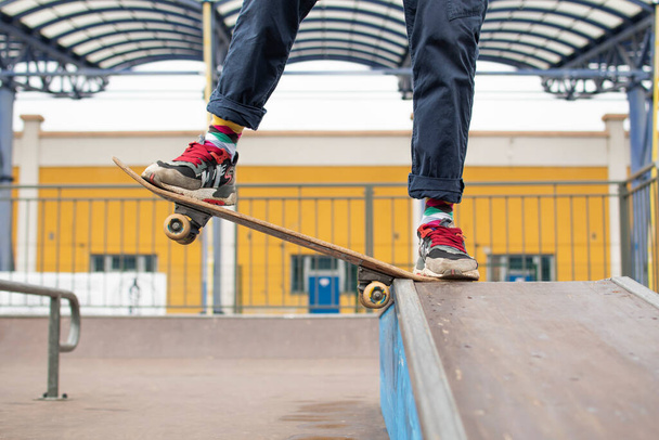 a young guy is engaged in jumping on a skateboard. an old skateboard. active sport among young people. injury-prone sport - Foto, immagini