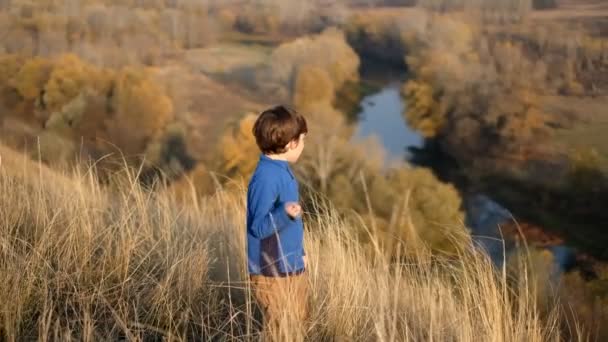 Jongensherfstreis naar de bergen. Een weekendje weg naar het nationale park met zijn zoon. Een prachtig landschap opent vanaf de top van de berg in de herfst bij zonsondergang. - Video