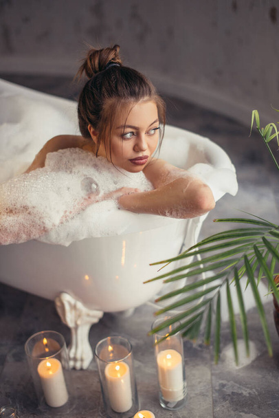 charming model spending free time in bathtub - Foto, afbeelding