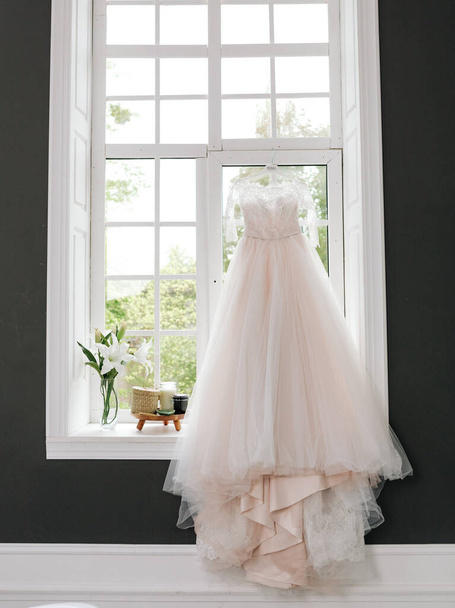 beautiful bride dress hung by the window wedding event elegance - Photo, Image