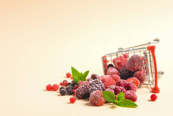 冷凍果実は買い物かごから注ぎ出されます。果実や果物の凍結と保存。長期保管。テキストの場所 - 写真・画像