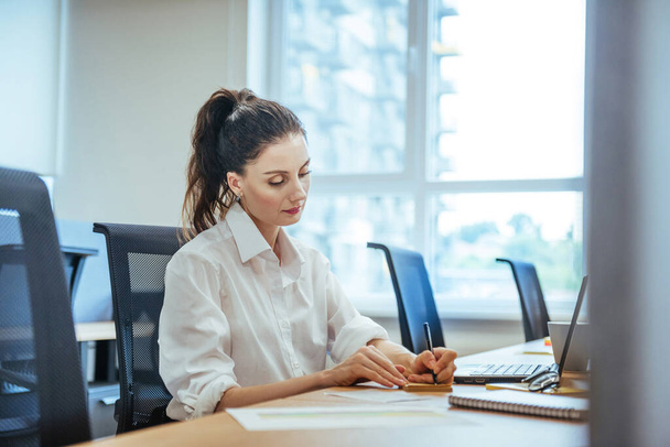 Femme d'affaires travaillant sur l'ordinateur portable dans le bureau - Photo, image