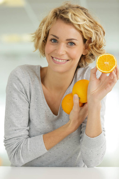 portrait of young woman with orange fruits - Photo, Image