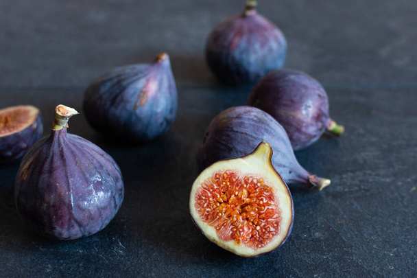 Fresh ripe figs on black background. Healthy tropical fig fruit.  - Fotó, kép