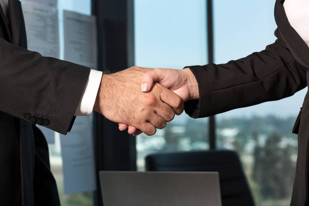 Geschäftsmann und Geschäftsfrau geben sich die Hand und treffen sich zum Abschluss. Handschlag-Kollegen im Büro - Foto, Bild